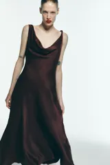 Vestido midi marrón de satén, con escote fluido, tirantes finos y espalda descubierta con lazo.