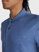 Chomba de piqué azul con cuello clásico, tapeta de dos botones y mangas cortas. Logo de Calvin Klein bordado en el pecho.