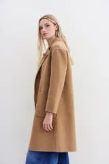 Tapado de paño color camel, con corte holgado, solapas y cierre cruzado con doble botón.
