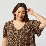 Blusa de animal print color marrón con negro, escote en V y mangas cortas.