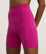 Conjunto deportivo de dos piezas, color fucsia vibrante, compuesto por un top deportivo de escote redondo y una bermuda ciclista de tiro alto.