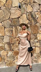 Vestido largo de satén color champagne, con breteles finos cruzados en la espalda.