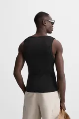 Musculosa negra ajustada al cuerpo, con cuello redondo y sisas amplias.