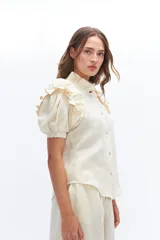 Camisa amarilla de lino con cuello mao y mangas cortas abullonadas con volados.