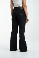 Pantalón de jean negro, de corte ajustado en cintura y caderas, con pierna ancha.