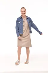 Campera de jean azul con cuello clásico, cierre frontal con botones metálicos, bolsillos con solapa en el pecho y ruedo desflecado.