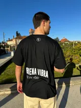Remera negra de corte semi oversize con estampa en la espalda que dice "BIENA VIBRA feel the vibes" en color blanco.
