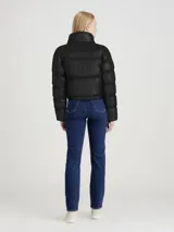 Campera puffer cropped negra de poliéster reciclado con cuello alto, cierre de cremallera, bolsillos laterales, puños elásticos, bajo ajustable con cordón y logo de Calvin Klein estampado en el pecho.