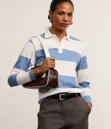 Blusa de algodón a rayas horizontales blancas y celestes, de mangas largas y cuello polo con botones.