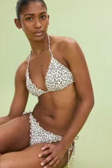 Top de bikini triangular con estampado floral en blanco y negro, ribete festoneado, tirantes finos y copas con relleno push-up.