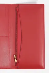 Billetera de estructura rígida color negro con logo metálico dorado de la marca Bimba y Lola en el frente. El interior cuenta con tarjetero y monedero con cierre de cremallera.