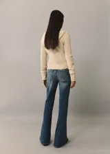 Cárdigan color crema de tejido de punto acanalado, con capucha con cordón ajustable y cierre frontal con cremallera.