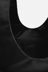 Bolso shopper negro de hombro fabricado en tejido técnico. Tiene un compartimento principal sin cierre, un bolsillo interior plano, un bolsillo interior con cierre de cremallera y dos bolsillos frontales con cierre magnético.