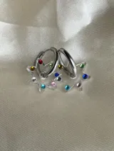 Par de aros dorados con forma de estrella negra.