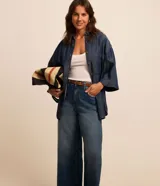 Pantalón wide leg cropped de jeans con tiro alto, trabillas en la cintura, cierre tradicional por botón y cremallera, bolsillos y bajo cortado.