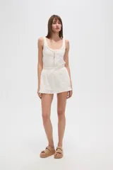 Minifalda blanca de algodón con cintura elastizada con cordón ajustable, volados en el ruedo y textura arrugada.