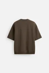 Sudadera negra de corte relaxed fit, confeccionada en tejido interlock de algodón con elasticidad. Tiene cuello redondo, manga corta y bajo acabado en rib.
