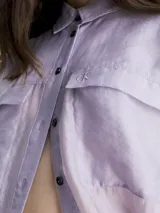 Camisa Calvin Klein de lyocell color lila, de corte holgado, manga larga, cuello en punta, cierre de botones, bolsillos con solapa en el pecho y logo bordado en el bolsillo del pecho.