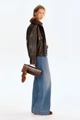 Pantalón de jean de algodón con leve stretch, tiro alto y pierna ancha. Presenta bolsillos de parche cuadrados en la parte delantera y bolsillos traseros. El lavado es celeste medio con efecto de desgaste vertical en las piernas.