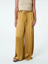 Pantalón relajado de corte amplio, color mostaza, con cintura ajustable y detalles de plisado.