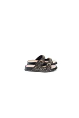 Sandalias planas negras de cuero con tachas doradas y plateadas, dos correas ajustables con hebillas metálicas y plataforma baja.