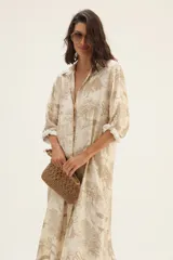 Vestido camisero largo de seda color blanco con estampado de serpientes, árboles y animales en azul.