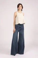 Blusa sin mangas color crema, con cuello redondo y bordes con pespuntes en contraste.