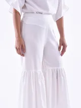 Pantalón blanco de corte cropped y ruedo acampanado con volantes.