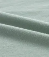 Remera de corte boxy, color verde menta, con cuello redondo y manga corta. Presenta un pequeño estampado en el pecho con texto en blanco.