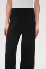 Pantalón de punto color crema, de corte ancho y tiro alto, con estampado animal print en los laterales.