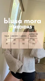 Blusa de tejido de punto color crudo con hilos de lurex que le dan un brillo sutil. Presenta un escote bote que puede usarse recto o caído sobre un hombro.