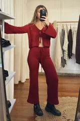 Conjunto de punto color borgoña, compuesto por un cárdigan corto con mangas acampanadas y lazo de ajuste frontal, y un pantalón de corte palazzo con cintura alta y cordón de ajuste.