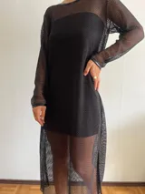 Vestido largo de red negro, con mangas largas y transparencias.