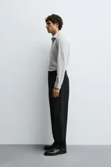 Camisa de manga larga con cuello italiano y cierre frontal de botonadura. Presenta un patrón de rayas verticales finas en tonos blanco y verde claro.