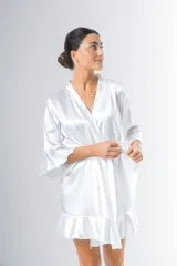 Bata corta color blanco de satén elastizado, con mangas tres cuartos con volados y lazo para atar en la cintura.