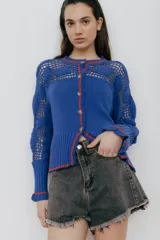 Cardigan azul de algodón con detalles de crochet y ribetes rojos.