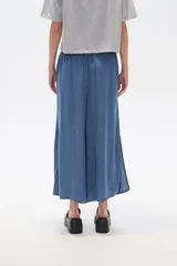 Pantalón capri de denim azul con cintura elástica y aberturas laterales en el ruedo.