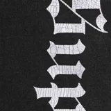 Pantalón de jogging negro de algodón con el logo de Supreme en tipografía Old English a lo largo de la pierna derecha.