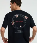 Remera negra de corte boxy, confeccionada en algodón. Presenta cuello redondo y mangas cortas. Estampa frontal y trasera con diseño de ángeles y texto "The Luck".