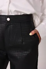 Pantalón negro de corte recto con textura símil cuero de cocodrilo.