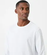 Remera blanca de algodón, manga larga, cuello redondo y corte clásico.