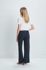 Pantalón acampanado azul marino de tejido de punto acanalado, con cintura alta y tres botones decorativos.