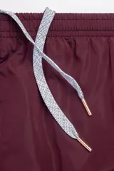 Short de baño color bordó, con cintura elástica ajustable, dos bolsillos laterales y uno trasero con cierre. Cuenta con suspensor de malla fina hipoalergénico y protección UV 50.