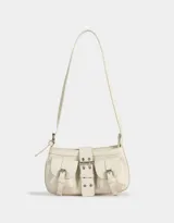 Cartera baguette color crudo de cuerina con correa regulable y hebillas frontales decorativas.