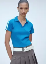 Polo deportivo azul con cuello clásico, corte entallado y mangas cortas con dos rayas blancas en los hombros.