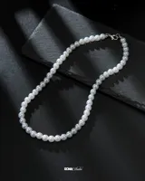 Collar de perlas blancas.