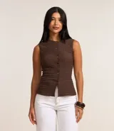 Blusa sin mangas de mujer, color marrón oscuro, con cuello redondo y abotonadura frontal. El tejido es texturizado (anarruga) y ajustado al cuerpo.