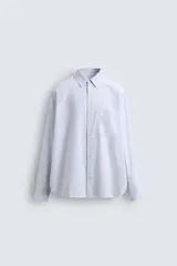 Camisa relaxed fit confeccionada en tejido de algodón a rayas verticales celestes y blancas. Cuello solapa, manga larga acabada en puño con botón, bolsillo plastrón en pecho y cierre frontal de botonadura.