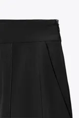 Pantalón negro de tiro medio confeccionado en hilatura con mezcla de viscosa. Presenta pinzas en el delantero y cierre lateral con cremallera oculta en la costura.