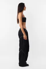 Pantalón negro de corte recto y tiro medio, con recortes en las piernas con detalle de vivo. Cintura con presillas y cinto correa con broche plástico incluido.